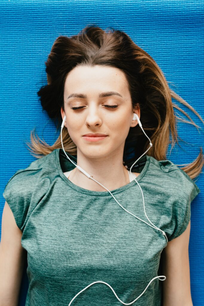 pexels-karolina-grabowska-4498195 fiatal nő zenét hallgat fülhallgatóval, meditatív állapotban, szemei lehunyva, pihen, feltöltődik